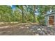 Large backyard featuring mature trees and a small garden area at 819 Swann Dr, Lakeland, FL 33809