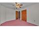Bedroom with ceiling fan, double closet, and view into hallway at 819 Swann Dr, Lakeland, FL 33809