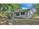 Side view of a single-story home featuring black shutters and a well-maintained yard at 819 Swann Dr, Lakeland, FL 33809