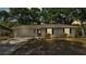 Charming single-story home with a gray exterior, attached garage, and well-manicured front yard at 819 Swann Dr, Lakeland, FL 33809