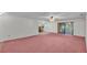 Spacious living room featuring plush pink carpet and sliding glass doors to the lanai at 819 Swann Dr, Lakeland, FL 33809