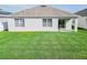 Well-manicured backyard features a spacious lawn, offering room to relax and play at 860 Killarney Ln, Auburndale, FL 33823