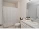 A well-lit bathroom featuring a shower curtain, vanity with sink, and a standard toilet at 860 Killarney Ln, Auburndale, FL 33823