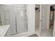 Bathroom with sliding glass shower doors and an open door to the closet filled with clothes at 860 Killarney Ln, Auburndale, FL 33823