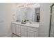 Bathroom features a large mirror, double sinks, and a clear view into the walk-in closet at 860 Killarney Ln, Auburndale, FL 33823