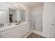 Bright bathroom featuring double sinks, walk-in glass shower, and a view into the walk-in closet at 860 Killarney Ln, Auburndale, FL 33823