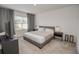 Well-lit bedroom featuring a queen-sized bed, carpeted floors and black bedside tables at 860 Killarney Ln, Auburndale, FL 33823