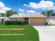 Charming single-story home with manicured lawn, lush hedges, and a two-car garage at 901 Spicewood Dr, Lakeland, FL 33801
