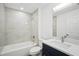 Updated bathroom featuring a shower-tub combo, vanity with quartz countertop and blue cabinetry at 950 W 2Nd St, Lakeland, FL 33805