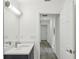 Bright bathroom has quartz countertop, stainless faucet, updated fixtures and adjacent hallway at 950 W 2Nd St, Lakeland, FL 33805