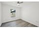 A well-lit bedroom with wood-look flooring, a window, and white walls at 950 W 2Nd St, Lakeland, FL 33805