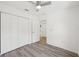 Bedroom with light grey luxury vinyl floors, white walls, and a ceiling fan with a walk-in closet at 950 W 2Nd St, Lakeland, FL 33805