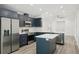 Modern kitchen boasts navy cabinetry, stainless steel appliances, center island and laminate flooring at 950 W 2Nd St, Lakeland, FL 33805