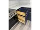A pull-out wooden spice rack next to the stove in this kitchen with modern, navy-blue cabinets at 950 W 2Nd St, Lakeland, FL 33805