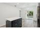 Kitchen island with navy blue cabinets and white countertops and a sliding glass door to the outside at 950 W 2Nd St, Lakeland, FL 33805