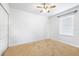 A bedroom with neutral walls, carpet, and a window for natural light with ceiling fan at 983 Revere Ave, Haines City, FL 33844