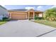 Charming single-Gathering home features a well-maintained lawn, a two-car garage, and beautiful landscaping at 983 Revere Ave, Haines City, FL 33844