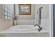 Bathroom featuring a soaking tub, a shower, tile accents, and natural light from window with blinds at 1036 Stoney Creek Dr, Lakeland, FL 33811