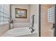 Bathroom featuring a soaking tub, a shower, tile accents, and natural light from window with blinds at 1036 Stoney Creek Dr, Lakeland, FL 33811
