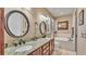 Bathroom features dual sinks with granite countertop, decorative mirrors, and a soaking tub at 1036 Stoney Creek Dr, Lakeland, FL 33811