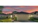 Inviting one-story home featuring a two-car garage and beautiful sunset lighting at 1036 Stoney Creek Dr, Lakeland, FL 33811