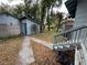 Shaded backyard with shed, fence, walkway, and partial stairs to home at 1217 King Ave, Lakeland, FL 33803
