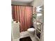 Well-lit bathroom with a modern vanity, shower with curtain, and a storage tower with ample space at 1217 King Ave, Lakeland, FL 33803