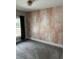 Bright bedroom showcasing a decorative accent wall, gray carpet, and a window with natural light at 1217 King Ave, Lakeland, FL 33803