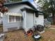 Side of home with lawn care equipment, windows with awnings and partial stairs at 1217 King Ave, Lakeland, FL 33803