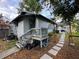 Charming home exterior showcasing a small deck and landscaped walkway leading to the backyard at 1217 King Ave, Lakeland, FL 33803