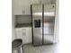 Kitchen featuring stainless steel refrigerator, white cabinets, granite countertops, and tiled backsplash at 1217 King Ave, Lakeland, FL 33803