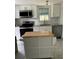 Well-equipped kitchen with stainless steel appliances, white cabinets, subway tile backsplash and moveable island at 1217 King Ave, Lakeland, FL 33803