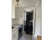 Convenient laundry closet equipped with stacked washer and dryer units and next to white cabinets at 1217 King Ave, Lakeland, FL 33803