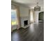 Bright living room featuring a decorative fireplace, hardwood floors, and large windows at 1217 King Ave, Lakeland, FL 33803