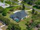Aerial view of home with screened pool enclosure, mature landscaping and green lawn at 130 Sylvana Ct, Auburndale, FL 33823