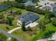 Aerial view of home with screened pool on a manicured lot with mature trees at 130 Sylvana Ct, Auburndale, FL 33823