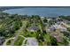 Aerial view of home near lake and surrounded by mature trees and manicured lawns at 130 Sylvana Ct, Auburndale, FL 33823