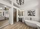 Bright bathroom featuring a soaking tub, vanity with makeup station, walk-in shower, and decorative chandelier at 130 Sylvana Ct, Auburndale, FL 33823