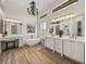 Modern bathroom with a soaking tub, chandelier, and dual vanities at 130 Sylvana Ct, Auburndale, FL 33823