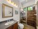 Modern bathroom showcasing a glass-enclosed shower, vanity sink, and framed mirror at 130 Sylvana Ct, Auburndale, FL 33823