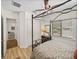 A bedroom with a four-poster bed, complemented by wood floors and a window with natural light at 130 Sylvana Ct, Auburndale, FL 33823