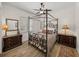 A traditionally styled bedroom with a four-poster bed, wood flooring, and complementary dark wood furniture at 130 Sylvana Ct, Auburndale, FL 33823