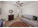 Bright bedroom with wood floors, a ceiling fan, a colorful rug, and an adjacent bathroom entrance at 130 Sylvana Ct, Auburndale, FL 33823