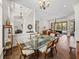 Open-concept dining area featuring a glass table, striped chairs, and views into the living room and pool area at 130 Sylvana Ct, Auburndale, FL 33823