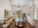 Elegant dining room with large window, glass-top table, and stylish seating; perfect for gatherings at 130 Sylvana Ct, Auburndale, FL 33823