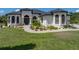 Beautiful exterior showcases the home's architecture, manicured lawn, and meticulously landscaped garden beds at 130 Sylvana Ct, Auburndale, FL 33823