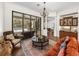 Open-concept living room with pool view, decorative columns and access to the kitchen area at 130 Sylvana Ct, Auburndale, FL 33823