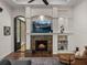 Living room featuring a cozy fireplace, built-in shelving, and stylish decor at 130 Sylvana Ct, Auburndale, FL 33823