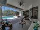 Covered patio with stylish seating, ceiling fan, brick flooring, and a refreshing view of the sparkling pool at 130 Sylvana Ct, Auburndale, FL 33823