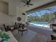 Screened-in patio with comfortable seating, a ceiling fan, and views of the pool and lush greenery at 130 Sylvana Ct, Auburndale, FL 33823